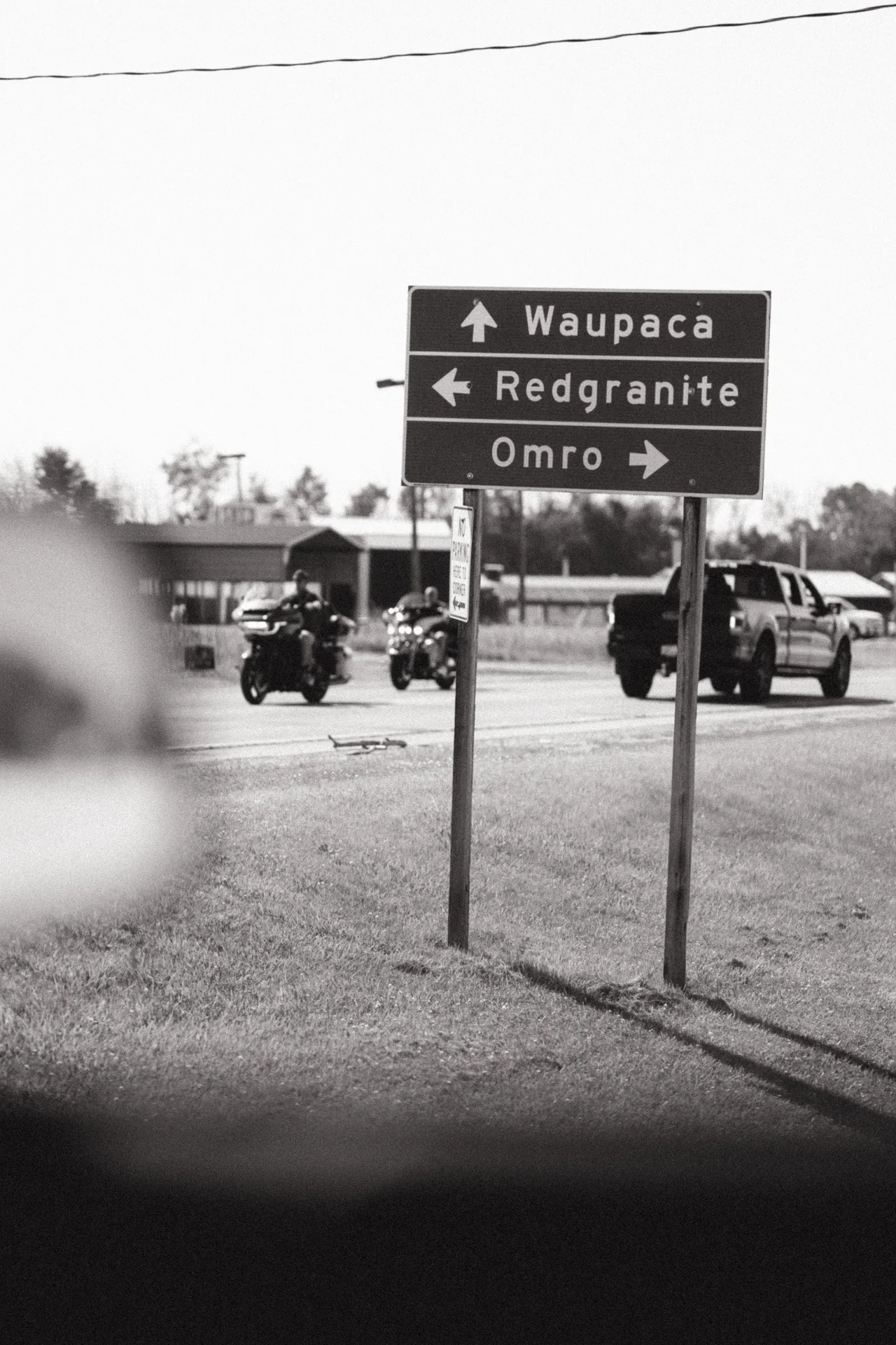 Road signs toward Waupaca, Redgranite and Omro as motorcycles pass in Berlin, Wisconsin