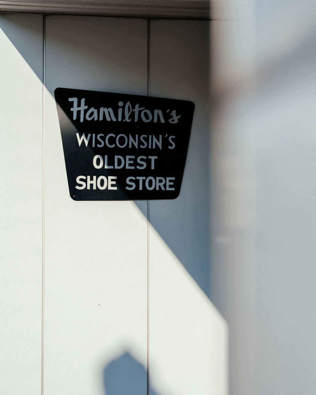 Hamilton's Wisconsin's Oldest Shoe Store sign in angled sunlight