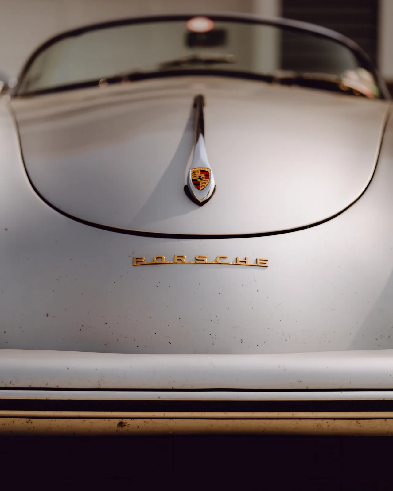 Porsche crest and gold Porsche script on the hood of Curt Cromwell’s 1956 Speedster