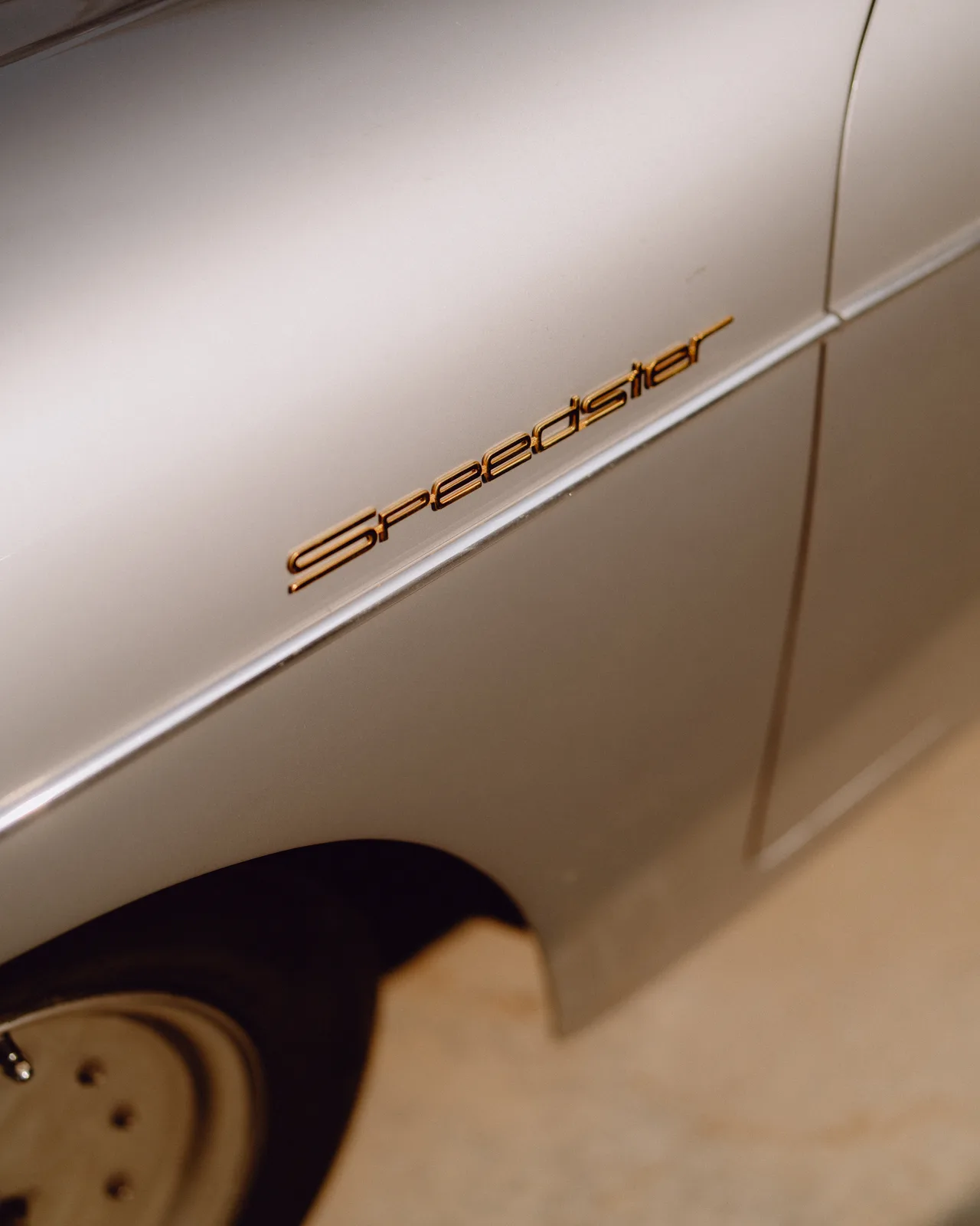 Gold Speedster script on the silver front fender of a 1956 Porsche 356 A