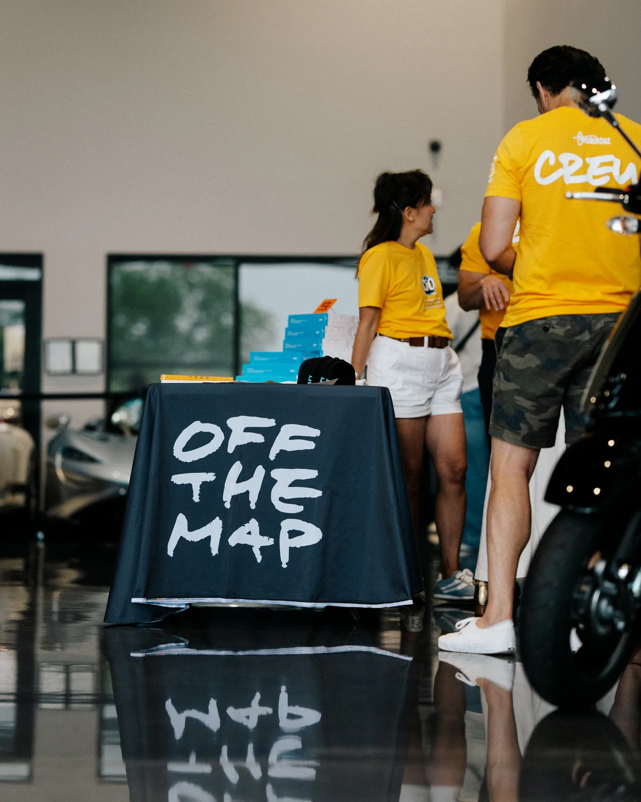 Off the Map books displayed as the Checkeditout crew sets up at Graham Rahal Performance