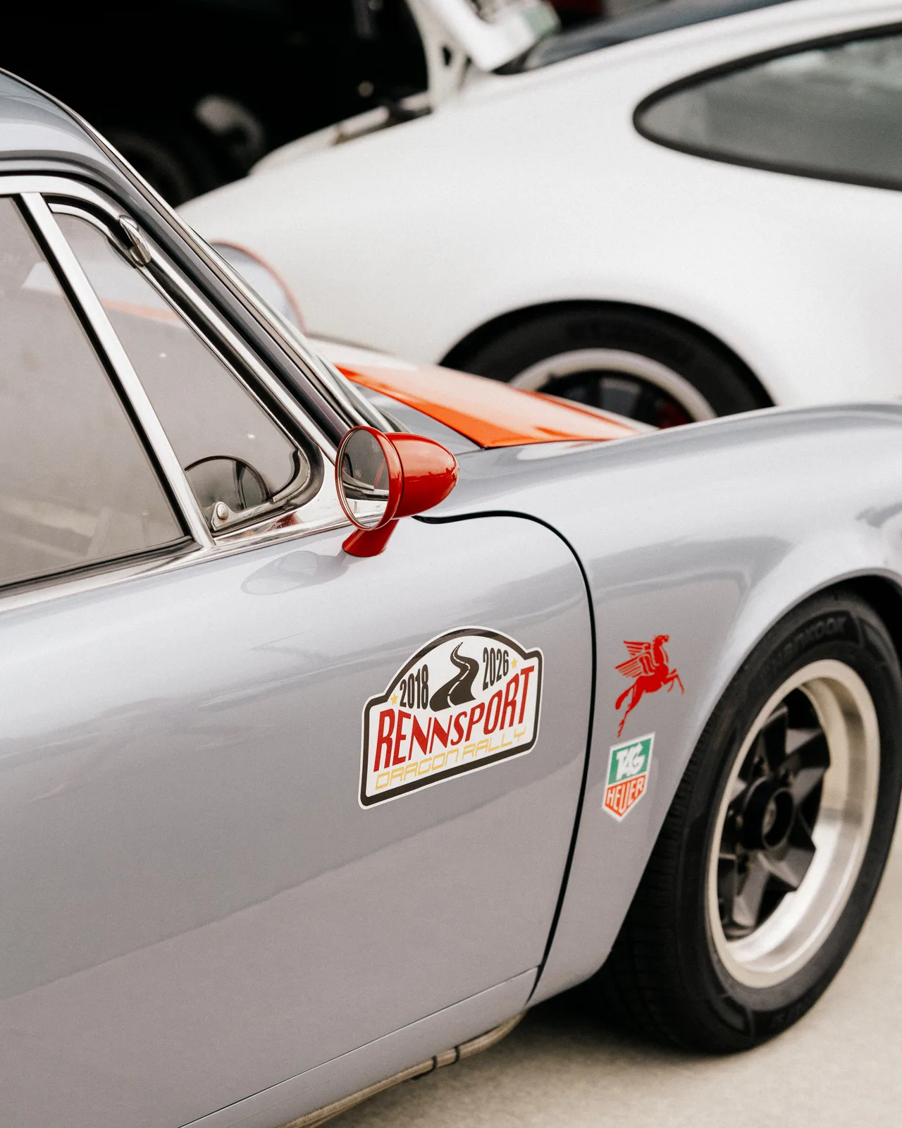 A silver vintage Porsche with a Rennsport door decal at Graham Rahal Performance