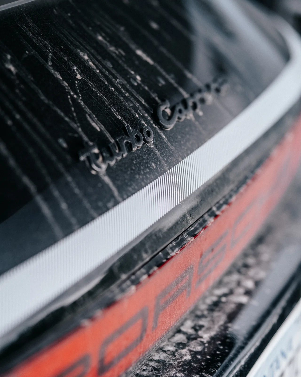 Porsche script seen through a rain-speckled surface