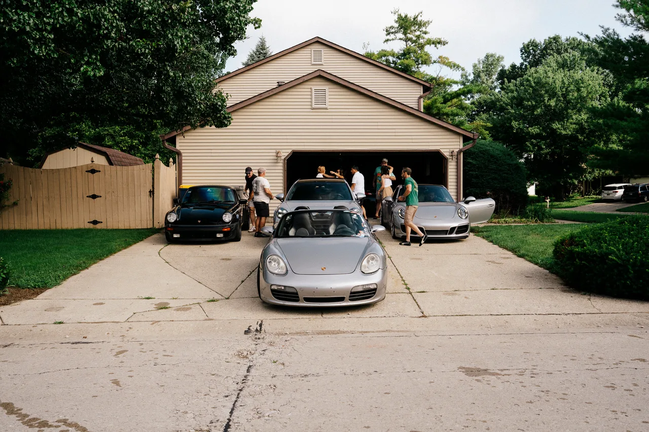 Three Porsches parked outside a residential garage